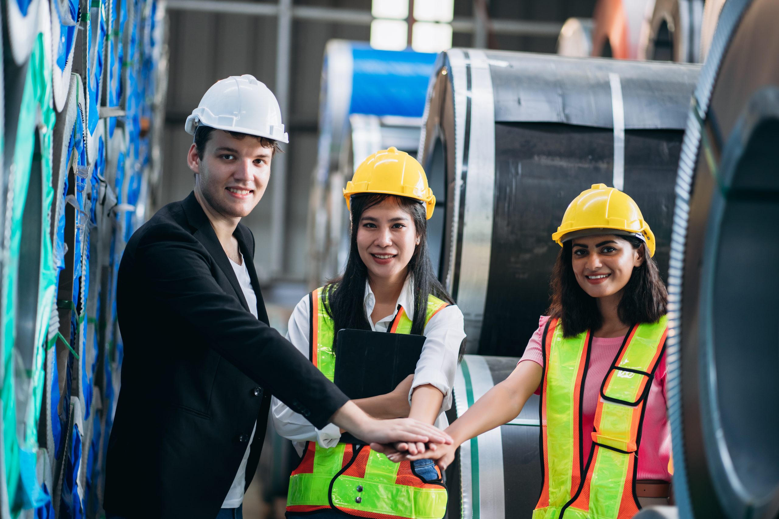Team engineers and foreman stack hand and shake hands to show success at factory machines. Worker industry join hand for collaboration.